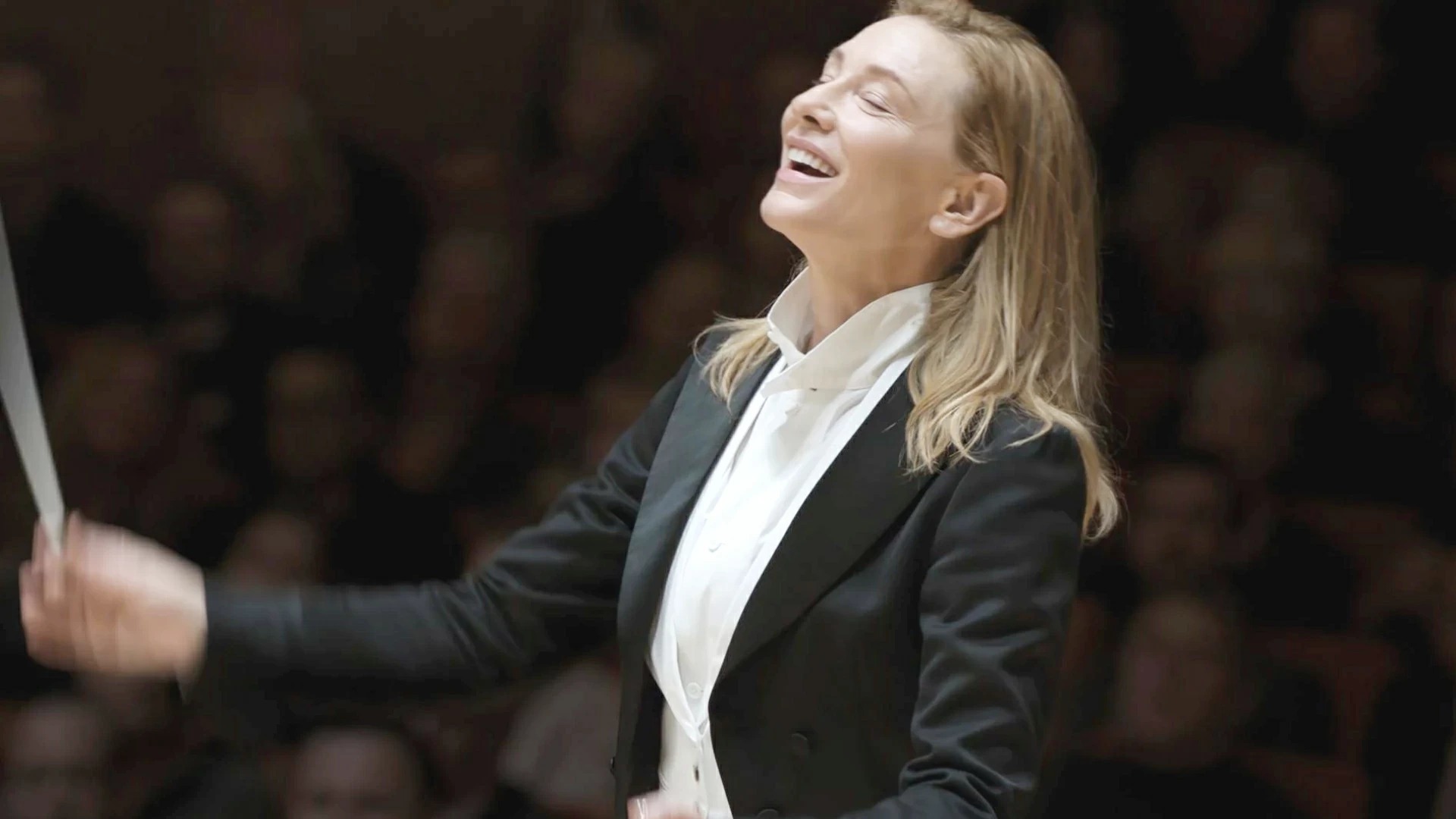 Cate Blanchett sorride mentre dirige l'orchestra