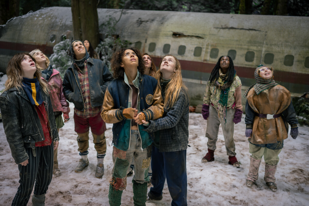 L-R: Sophie Thatcher as Teen Natalie, Jenna Burgess as Teen Melissa, Kevin Alves as Teen Travis, Courtney Eaton as Teen Lottie, Jasmin Savoy Brown as Teen Taissa, Sophie Nélisse as Teen Shauna, Liv Hewson as Teen Van, Nia Sondaya as Teen Akilah and Samantha Hanratty as Teen Misty in Yellowjackets, episode 8, season 4, streaming on Paramount+, 2026. Photo Credit: Eric Milner/Paramount+.
